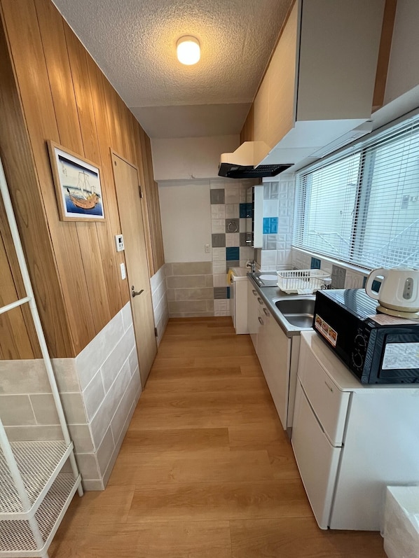 Kylskåp, mikrovågsugn, spishäll och grytor/köksredskap