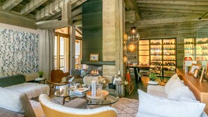 Un salón espacioso con chimenea, una zona de bar con estantes llenos de botellas y una gran pared de firmas.