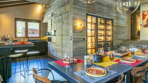 Una cocina moderna con una isla grande, paredes de madera y una cava de vinos.