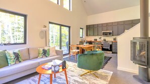A modern living room with a sofa, a coffee table, and a fireplace. - Hodag House | Magical Cabin & Creature Comforts (Herbster)