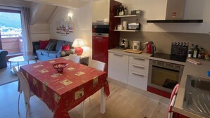 Espai vital reduït amb zona de menjador, petita cuina i seients per seure.