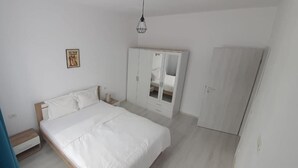 A bedroom with a bed, wardrobe, and a mirror cabinet. - VISAJ Metropolitan (Giroc)