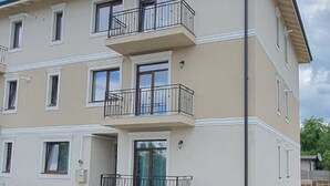 A multi-story residential building with balconies, a flat roof, and a paved ground floor. - VISAJ Metropolitan (Giroc)