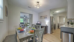 A modern kitchen with a dining area, wooden flooring, and stainless steel appliances. - River Bend Bliss: Where Memories flow with the River (Cedar Creek)