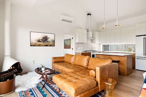 Uma sala de estar moderna com sofá de couro, mesa de centro e tapete.