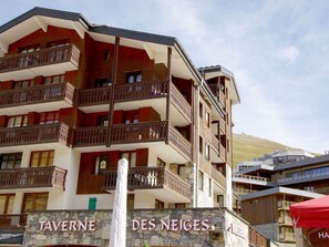 Um hotel com várias andares, varandas e fachada de pedra.