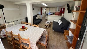 A compact living space with a dining area, kitchenette, and a sofa. - Spacious apartment for 8, garden and WIFI, near shops in Pra Loup (Pra-Loup)