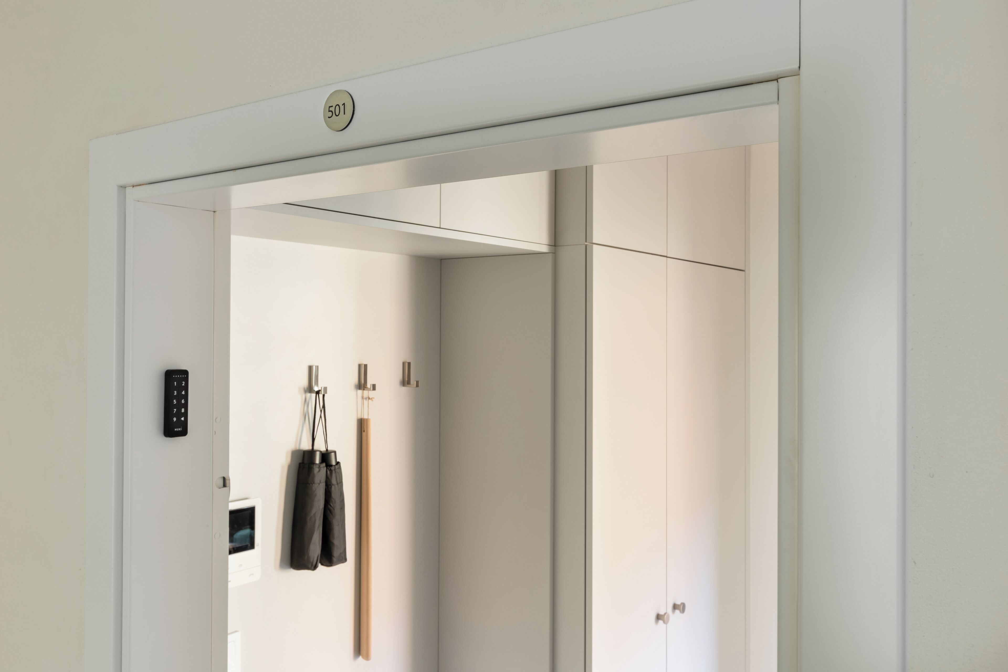 A modern elevator with a control panel and a door number sign.