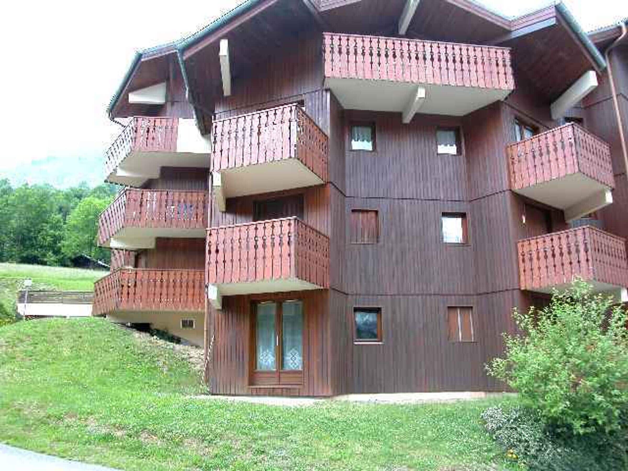 A multi-story building with balconies, a door, and windows.