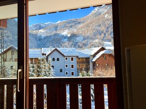 A view of a mountain landscape with snow-covered trees and buildings.