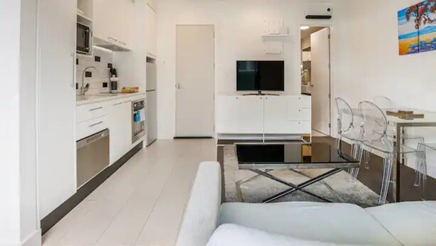 Eine moderne Wohnung mit Küchenzeile, Essbereich und Wohnzimmer.