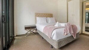 Ein Schlafzimmer mit einem Bett, Nachttischen, einem Kleiderschrank und einer Deckenleuchte.