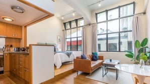 Un appartement moderne comprenant une cuisine, un lit, un canapé et un coin repas.