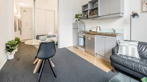 A compact living space with a kitchenette, a dining area, and a seating area.