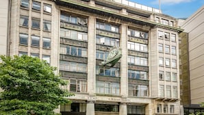 A multi-story building with a prominent clock on the facade, featuring the name 'The Guardian' at the ground level.