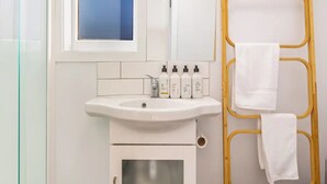 A bathroom with a white sink, a mirror, and a towel rack. - Stunning Studio In Grey Lynn! (Auckland)