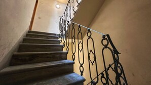 Una scala con ringhiera in ferro battuto e una parete liscia.