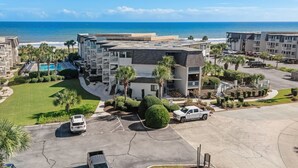 A multi-story hotel with a pool, parking area, and ocean view. - Ocean Forest Villas Unit C301 - Ocean view (Myrtle Beach)