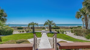 A pathway leading to a beach with palm trees and a clear view of the ocean. - Ocean Forest Villas Unit C301 - Ocean view (Myrtle Beach)