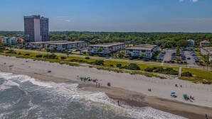A coastal hotel with multiple buildings, a beach, and a parking area. - Ocean Forest Villas Unit C301 - Ocean view (Myrtle Beach)