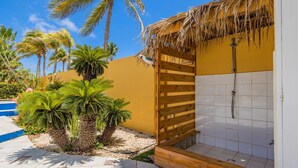 Ein Badezimmer mit Holztür, Dusche und gefliesten Wänden.