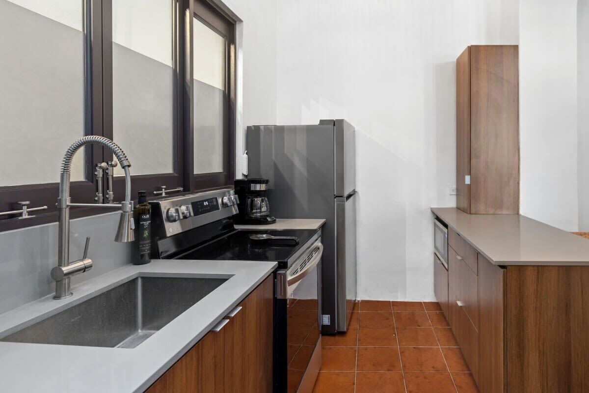 A compact kitchen with a sink, stove, and refrigerator.