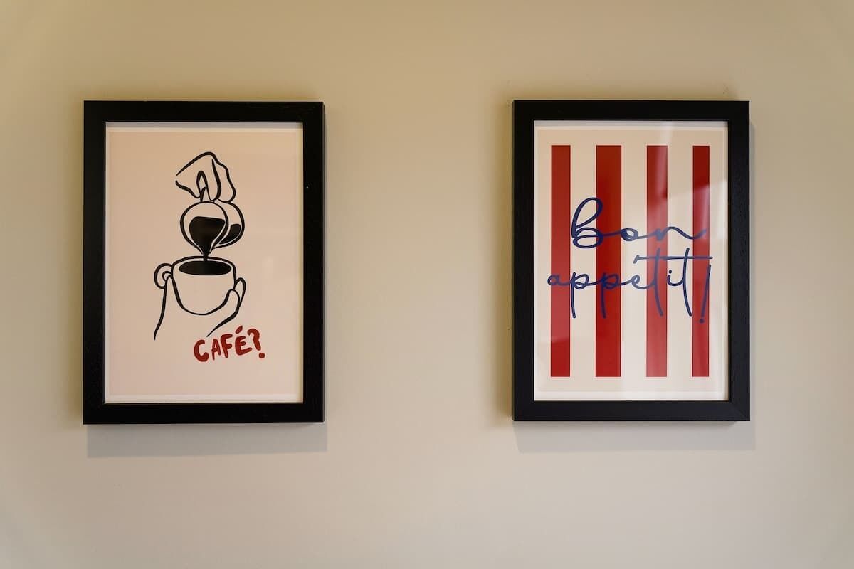 Deux œuvres d’art encadrées sont accrochées au mur.