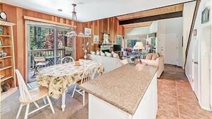 A compact kitchen with a dining area, wooden walls, and a large window. - 45 Coeur Du Lac 3BR/2BA Incline Village, Pool & Mtn View (Incline Village)