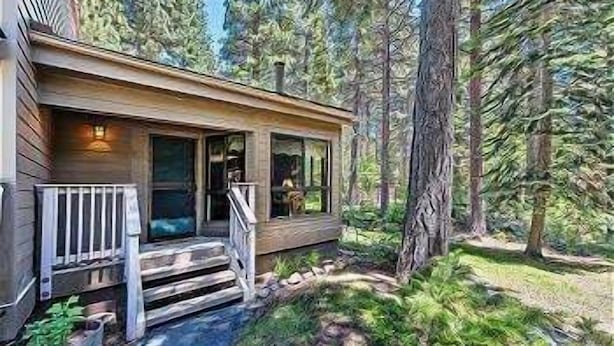 A cabin with a wooden exterior, a porch, and a view of a forested area. - 45 Coeur Du Lac 3BR/2BA Incline Village, Pool & Mtn View (Incline Village)