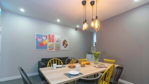 A dining area with a wooden table, chairs, and artwork on the wall. - Middlesborough City Centre Studio (Middlesbrough)