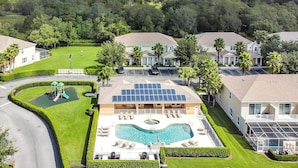 Área residencial com piscina, painéis solares e parquinho.