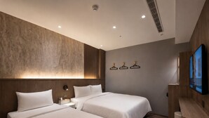 A modern hotel room with two beds, a large wall-mounted TV, and a wooden desk. - Fun Stay Inn Ximen (Taipei)