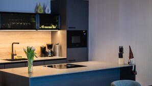 Una cocina moderna con una isla central, una cafetera y un fregadero.