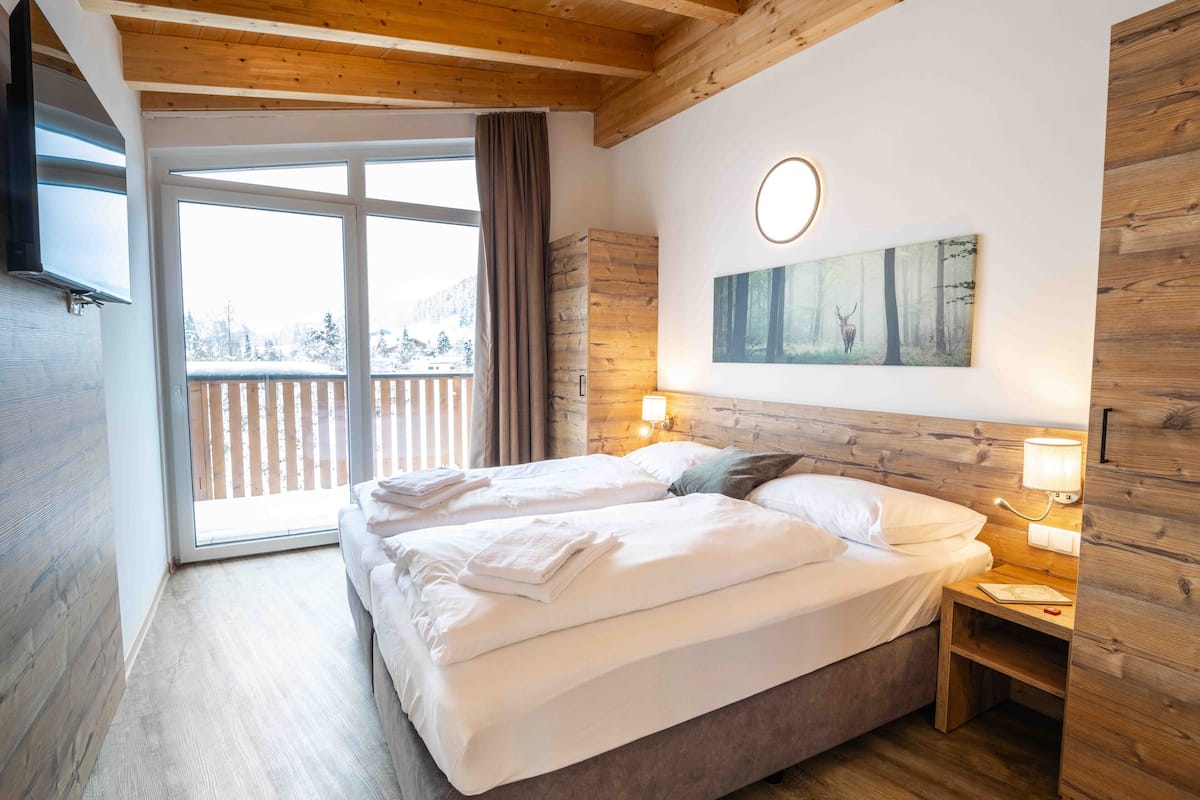 Een slaapkamer met een groot bed, een houten hoofdeinde en een schilderij aan de muur.