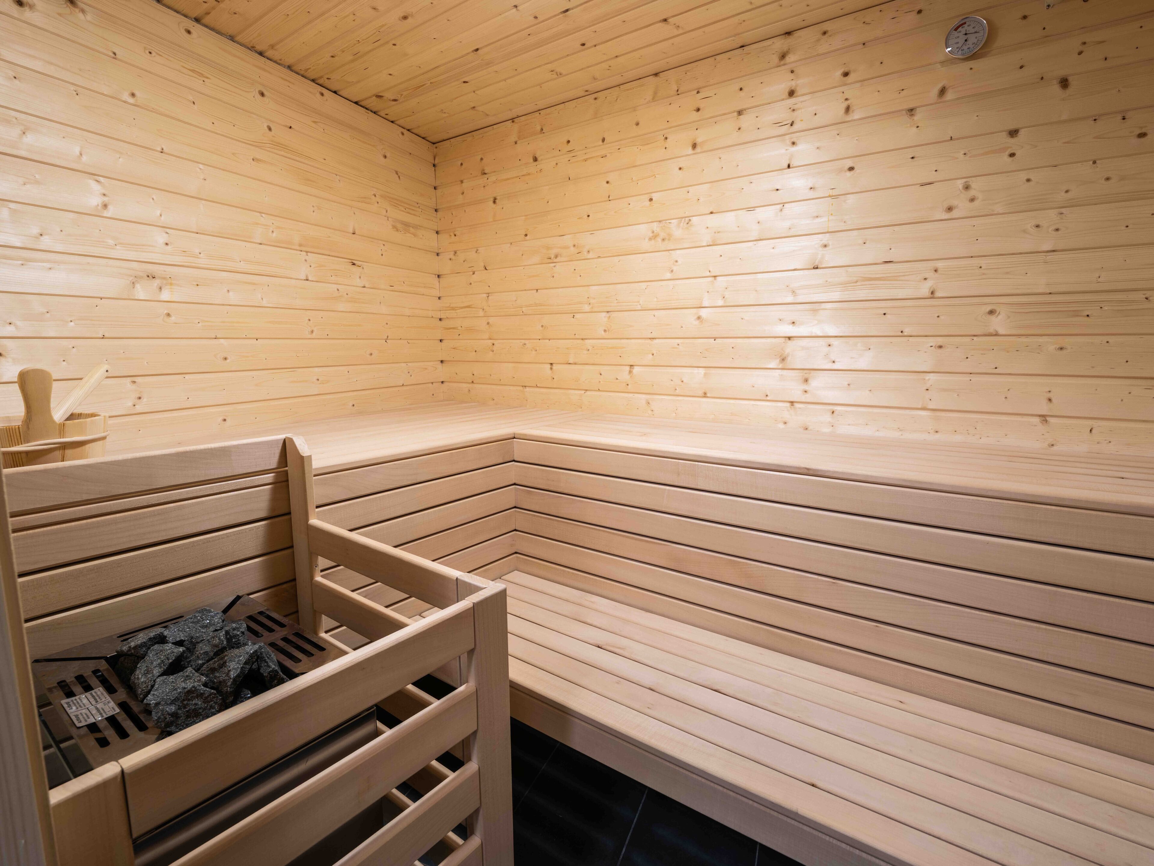 A sauna with wooden benches and a bench with a towel rack.
