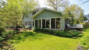 A house with a covered porch, a lawn, and trees.