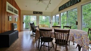 A dining area with a round table, chairs, and a ceiling fan.