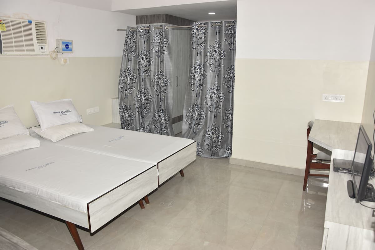 Una habitación de hotel con cama, escritorio y zona de ducha.