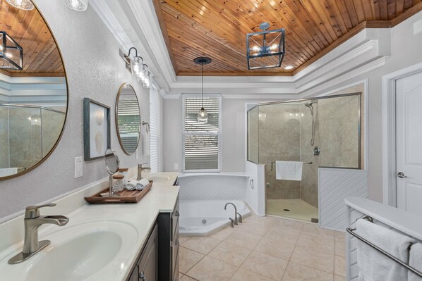 A spacious bathroom with a large vanity, a freestanding bathtub, and a walk-in shower. - Cove Front, Kayak, Pedal Boat, and Nearby Restos (Rocky Mount)