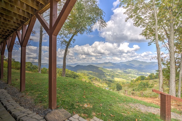 A covered outdoor area with wooden beams and a stone pathway.