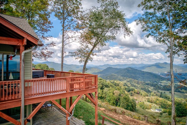 A wooden deck with a view of a mountainous landscape. - Unbelievable Views, Hot Tub, Fire Pit, Fire Table, Indoor Fireplace (Waynesville)
