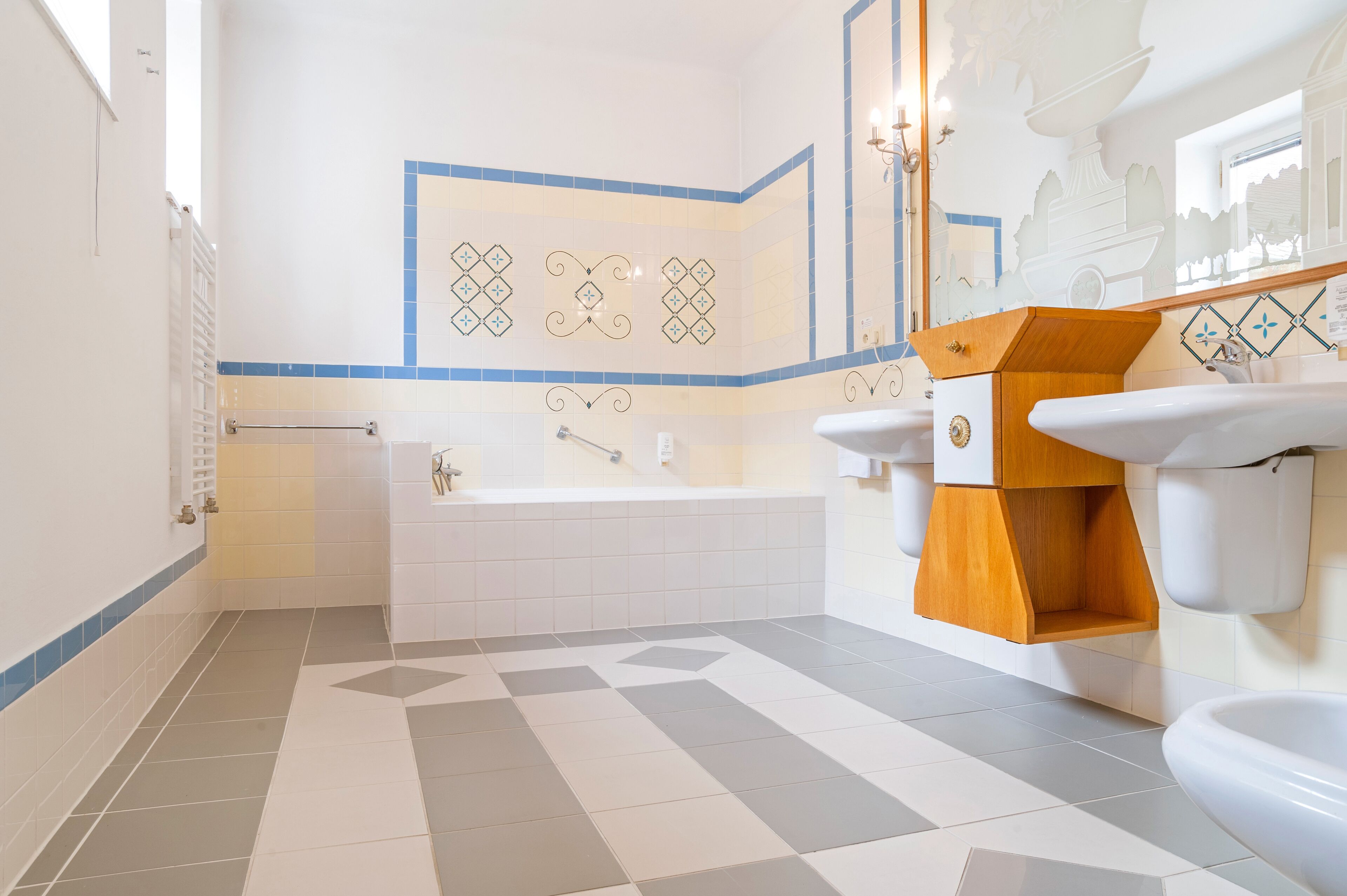 Un baño moderno con bañera, dos lavamanos y un mueble de tocador con gabinete de madera.