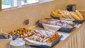 A buffet counter with various baked goods, including bread and pastries, arranged in baskets. - Tři Lilie (Frantiskovy Lazne)