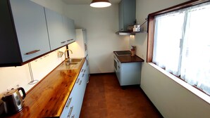 Uma cozinha compacta com bancada de madeira, pia e armários.