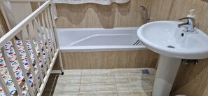 Bathroom features a bathtub, sink, and crib.