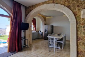 Enjoy meals in the kitchen with a central island and dining area, featuring a refrigerator and microwave.