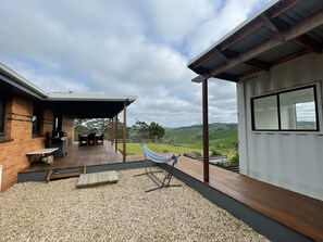Un espace extérieur abrité comprenant un barbecue, des sièges et un hamac.