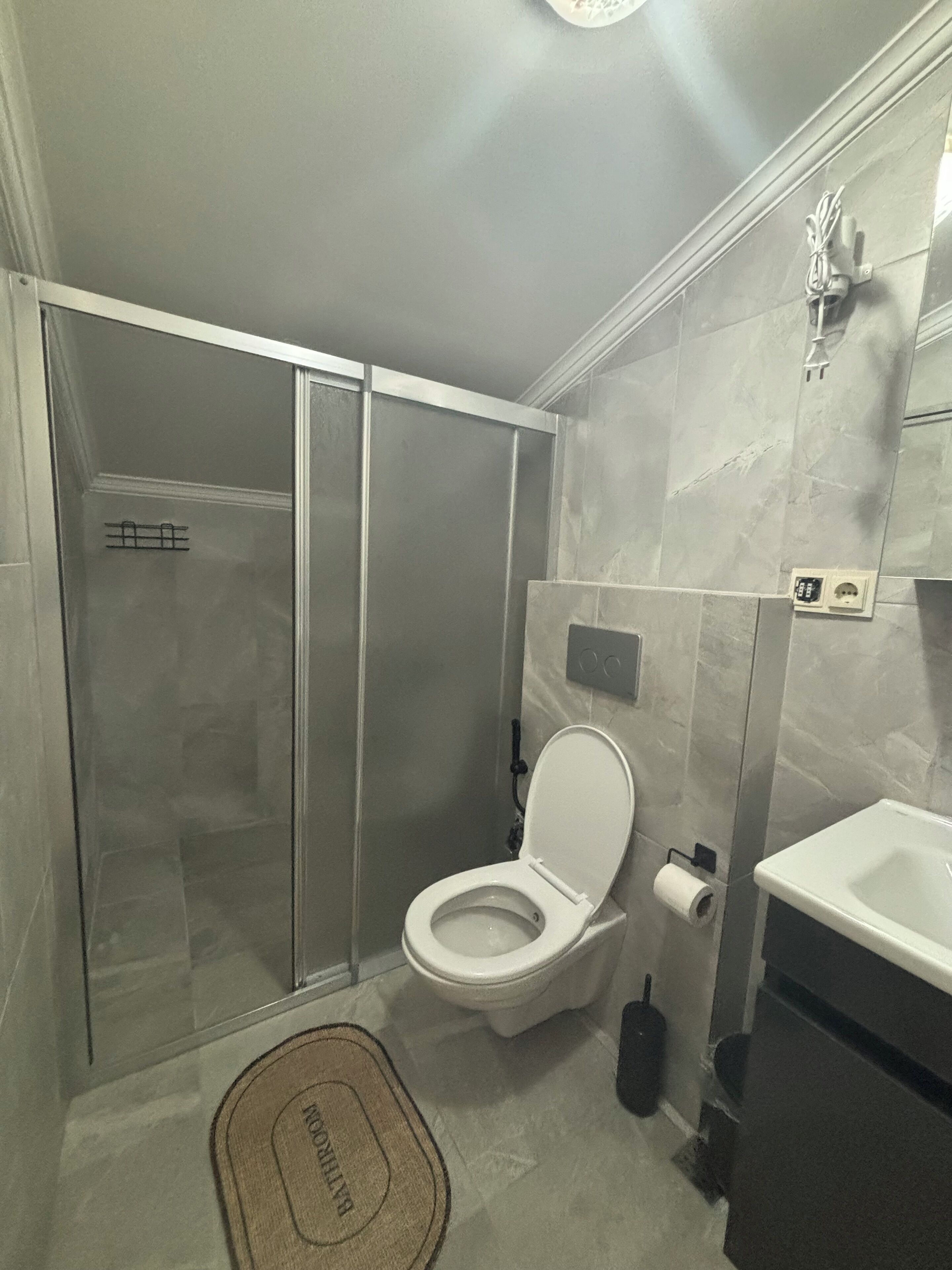 Un baño con inodoro, lavamanos y ducha.