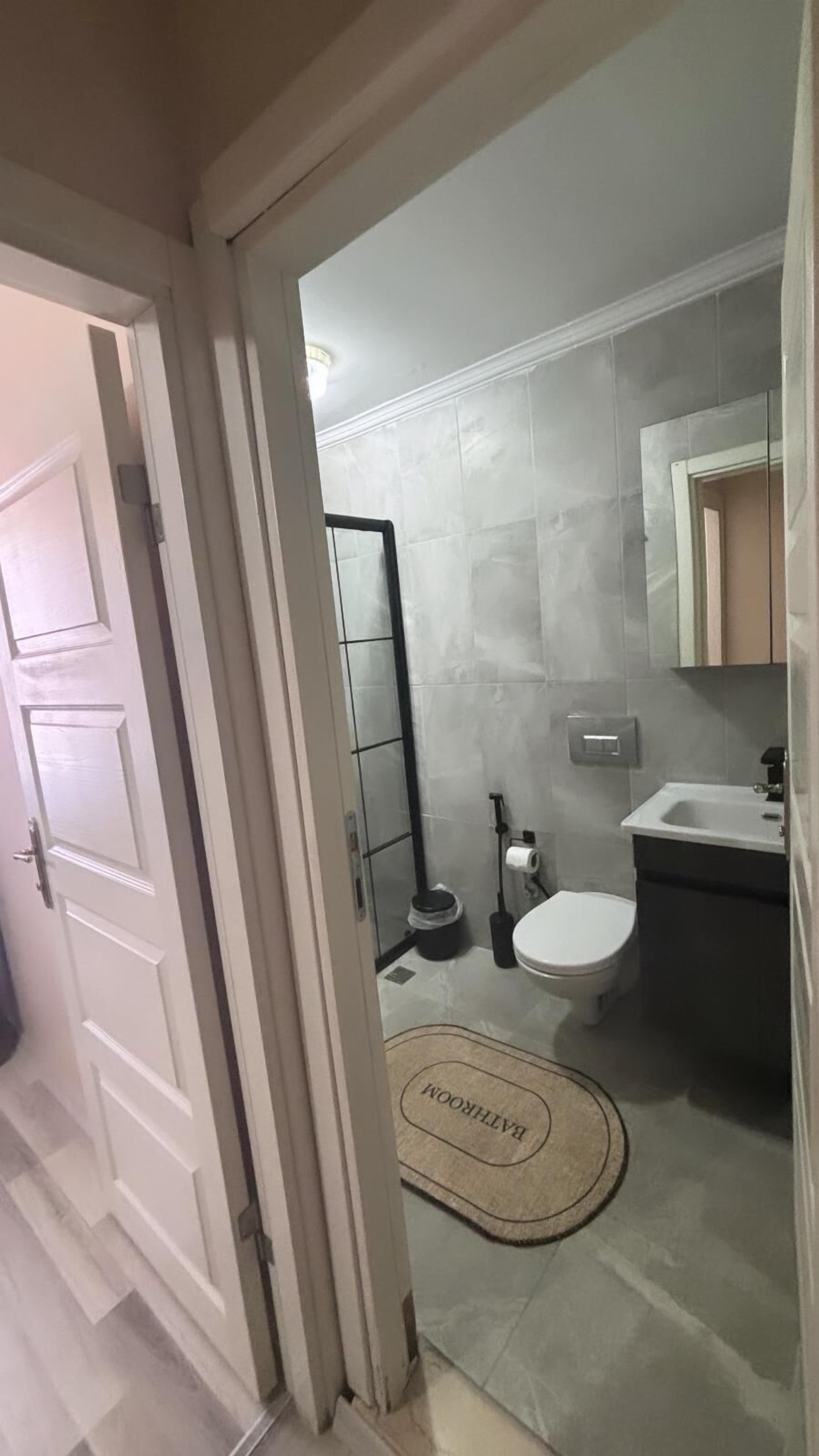 A bathroom with a toilet, sink, and shower area.