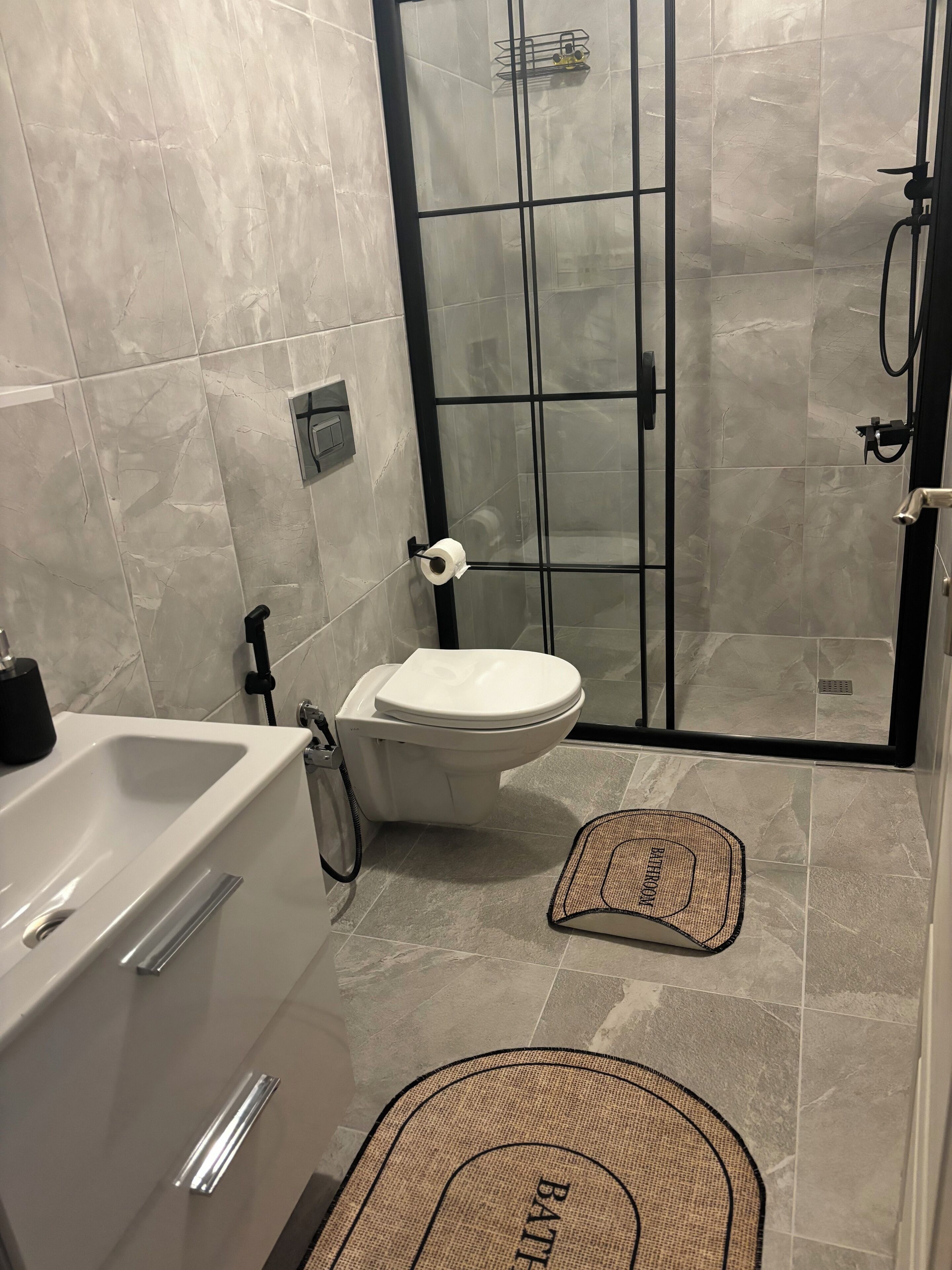 A bathroom with a bathtub, toilet, and glass-enclosed shower.